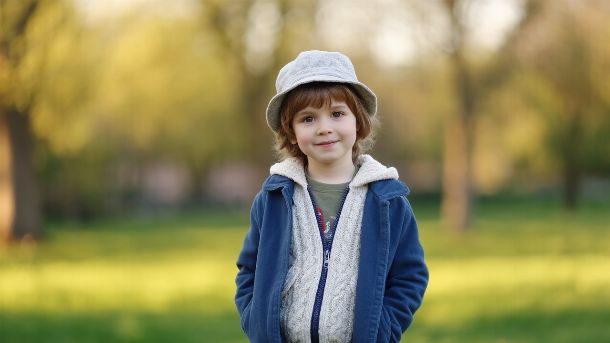 Enfant  habillé en couches adaptées au printemps jouant dehors dans un parc, confortable et protégé contre la fraîcheur