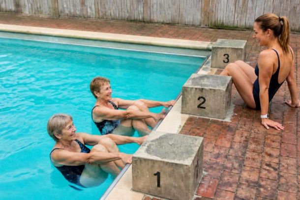 Personnes seniors faisant de l'exercice dans une piscine Personnes seniors faisant de l'exercice dans une piscine